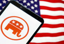 ‘Socialist’ Blitz Hits Swing Districts Republican elephant logo on phone, American flag background.