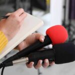 Trump’s Map Rejected: SHOCKING GOP Split Journalist holding two microphones while writing in a notebook