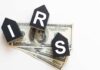 Audit Dollars VANISH From IRS – DETAILS Blocks spelling 'IRS' placed on top of hundred dollar bills featuring Benjamin Franklin