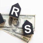 Audit Dollars VANISH From IRS – DETAILS Blocks spelling 'IRS' placed on top of hundred dollar bills featuring Benjamin Franklin