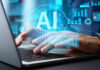 Person typing on laptop with AI hologram
