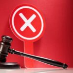 Judge's gavel with red cross sign in background