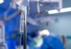 Doctors Pull Off Impossible Split IV drip in focus with surgeons operating in the background