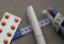 Fast-Food Flip: GLP-1 Changes Everything Medication blister pack, insulin pens, and tape measure on a gray surface