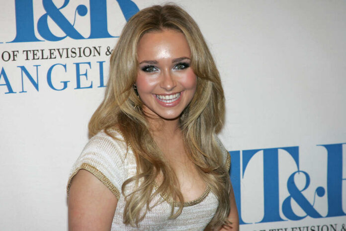 Smiling woman with long blonde hair at a media event