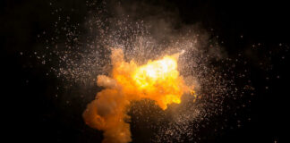 Bright explosion against a dark background with sparks.