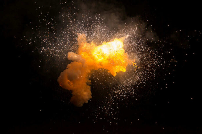 shutterstock_372777733 Bright explosion against a dark background with sparks.