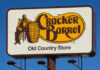 Cracker Barrel Old Country Store sign featuring a man sitting next to a barrel