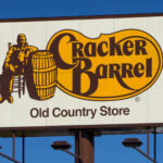 What’s Cracker Barrel Plotting With THIS Change Now? Cracker Barrel Old Country Store sign featuring a man sitting next to a barrel