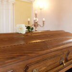 Shock Death Rocks Sports World A wooden casket with a white rose placed on top in a solemn setting