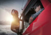 VIDEO: American Truckers Are Fed Up Truck driver looking out window at sunset.