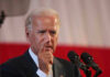 Joe Biden speaking at a podium, pointing his finger during a speech