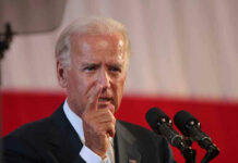 Joe Biden speaking at a podium, pointing his finger during a speech