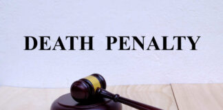 A wooden gavel resting on a block with the words 'DEATH PENALTY' in bold above it
