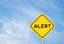 Yellow alert sign against a blue sky