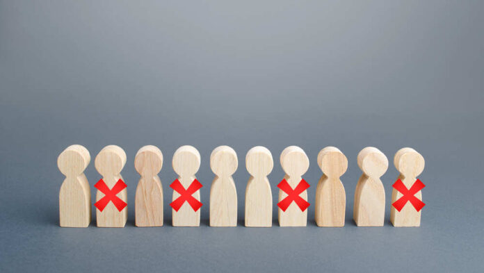 Row,Of,People,With,Red,X.,Reductions,And,Work,Layoffs Wooden human figures in a row with red X marks on some
