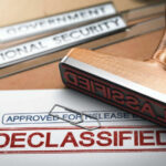 Declassified stamp on government document with paperclip