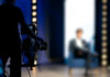 camera operator filming blurred person on stage
