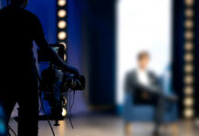 camera operator filming blurred person on stage