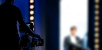 camera operator filming blurred person on stage