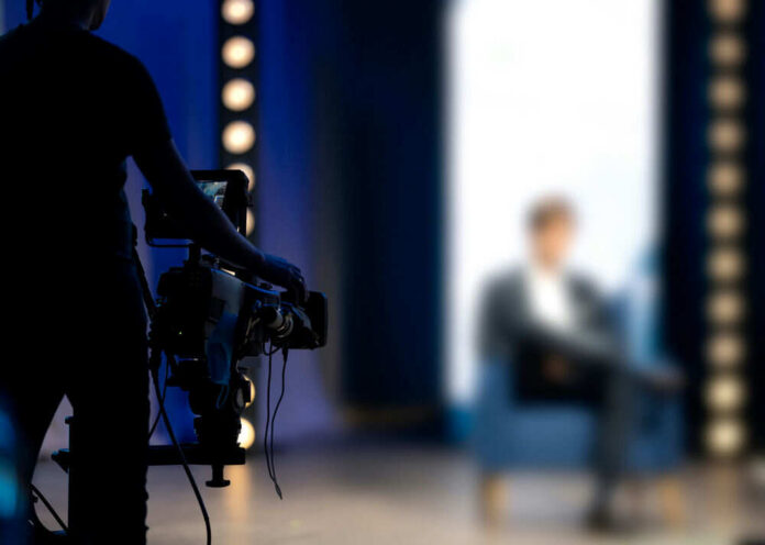 shutterstock_1901472724 camera operator filming blurred person on stage