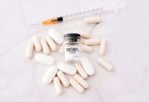 Fentanyl citrate vial surrounded by various pills and syringe.