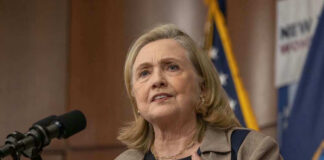 Hillary Clinton speaking at a podium with a microphone