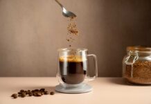 Centenarian Habit: Coffee, Wine, Shockingly Simple Spoon sprinkling instant coffee granules into a glass cup