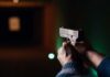 Hands aiming a pistol at an indoor shooting range