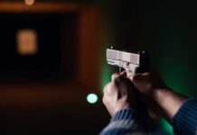 Shooting Stuns White House Hands aiming a pistol at an indoor shooting range