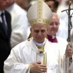 Catholic bishop in white vestments holding a crosier