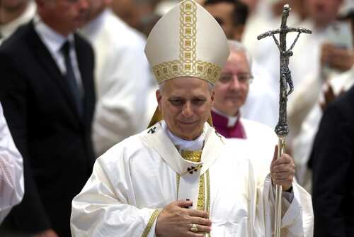 Catholic bishop in white vestments holding a crosier