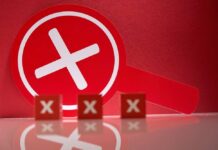 DOJ Ballot Rush BLOCKED A red magnifying glass with a cross symbol against a red background