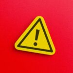 Yellow warning sign with exclamation mark on red background