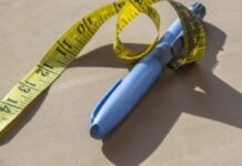 Blue pen with yellow measuring tape on a table