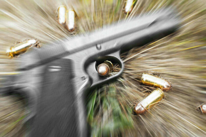 Pistol and bullets on grass with motion blur effect.