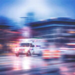 Ambulance speeding through city street at night