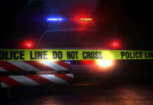 Mid-Drive Teen Killing – Suspects Nabbed Police car with flashing lights behind caution tape.