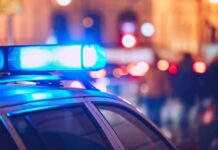 Close-up of a police car with blue emergency lights in a city at night